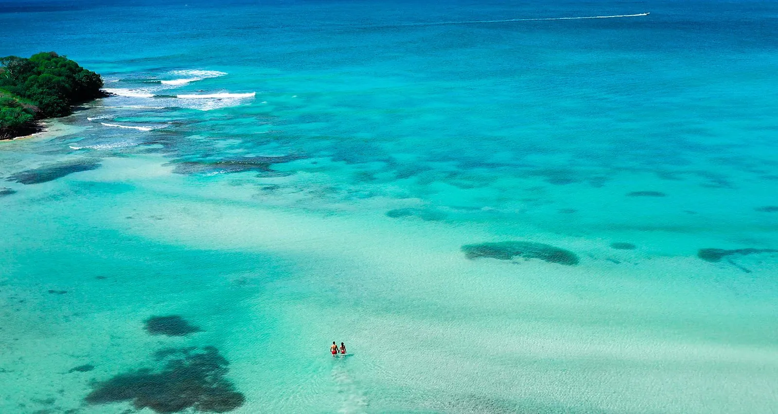 Deux baigneurs debout dans les eaux peu profondes et turquoise des fonds blancs, Martinique