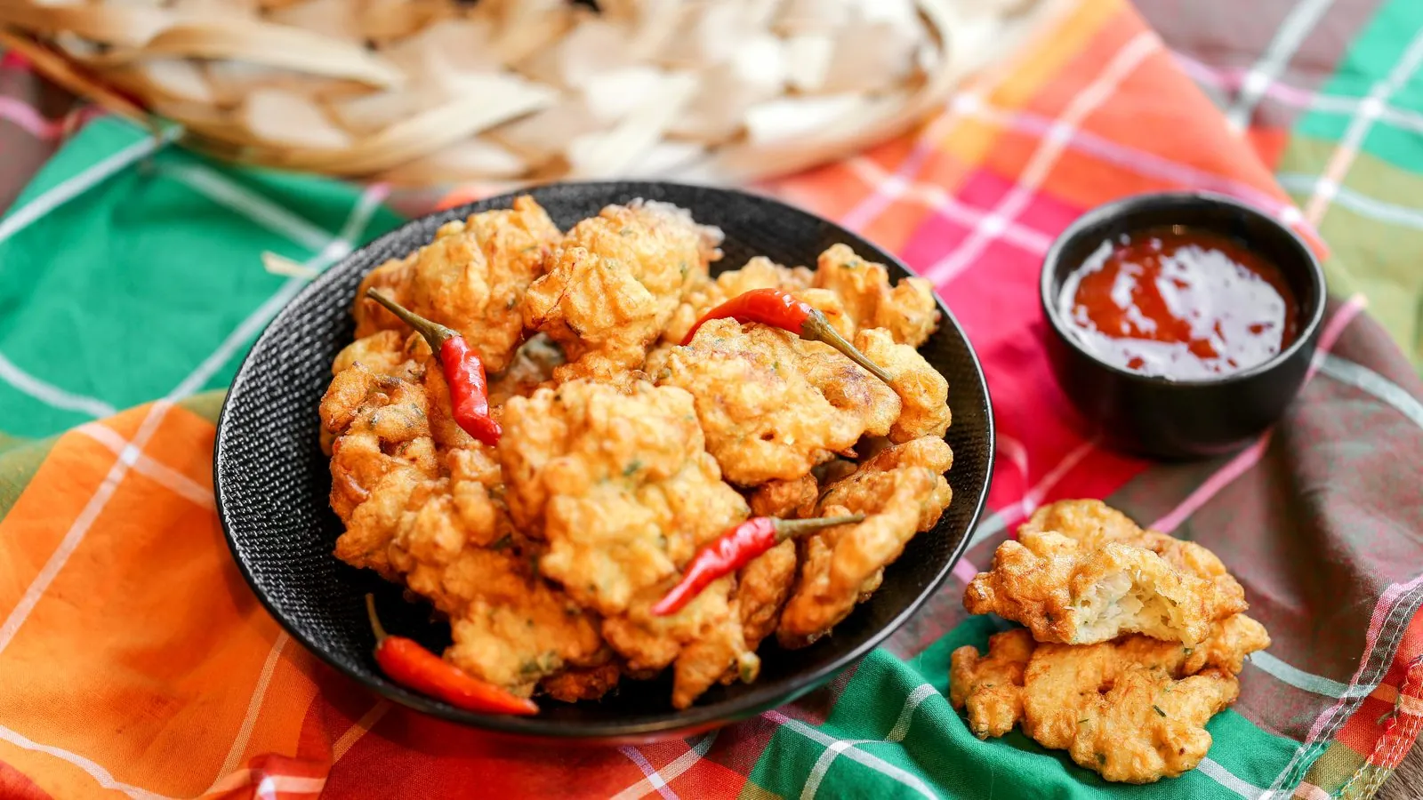 Assiette d'accras de morue et piments sur un tissu madras aux couleurs créoles