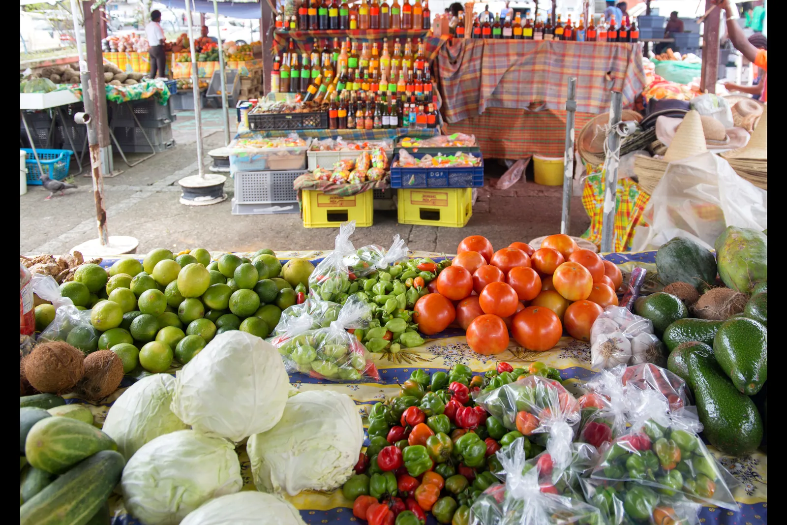 Étal de fruits, légumes et rhums arrangés sur un marché créole en Martinique